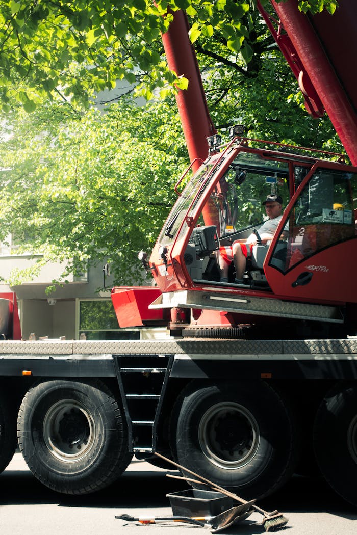 why-choose-us Crane operator in cab, surrounded by nature and machinery in sunny weather.